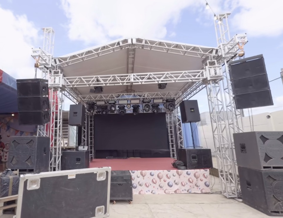 Estrutura de palco montada com grades de contenção de público, durante o dia