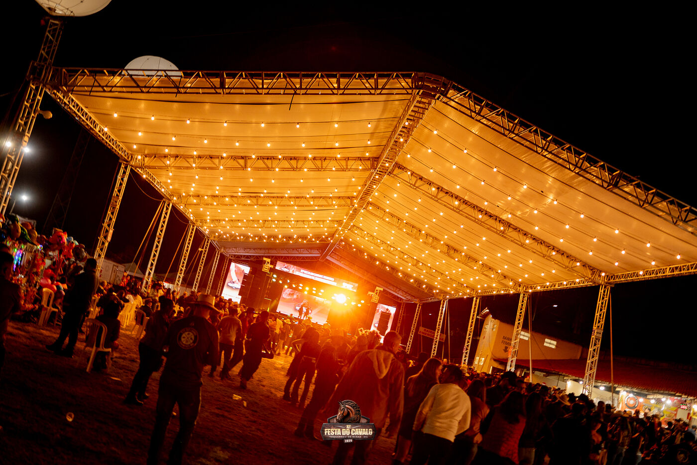 Tenda MS Produções e Eventos montada em evento noturno, com estrutura de treliça e iluminação