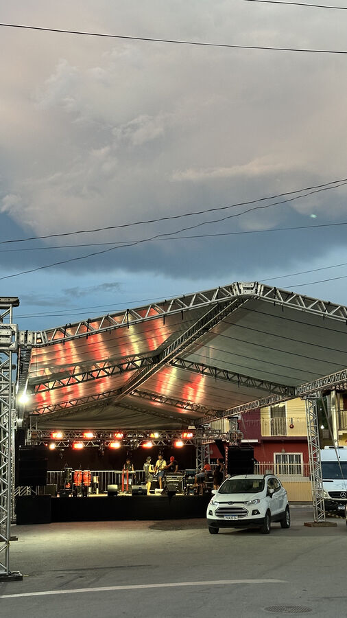 Estrutura de tenda com treliça e iluminação cênica ao entardecer