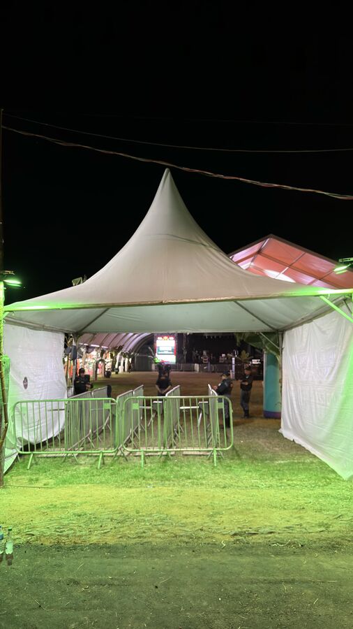 Tenda piramidal montada com grades de contenção de público
