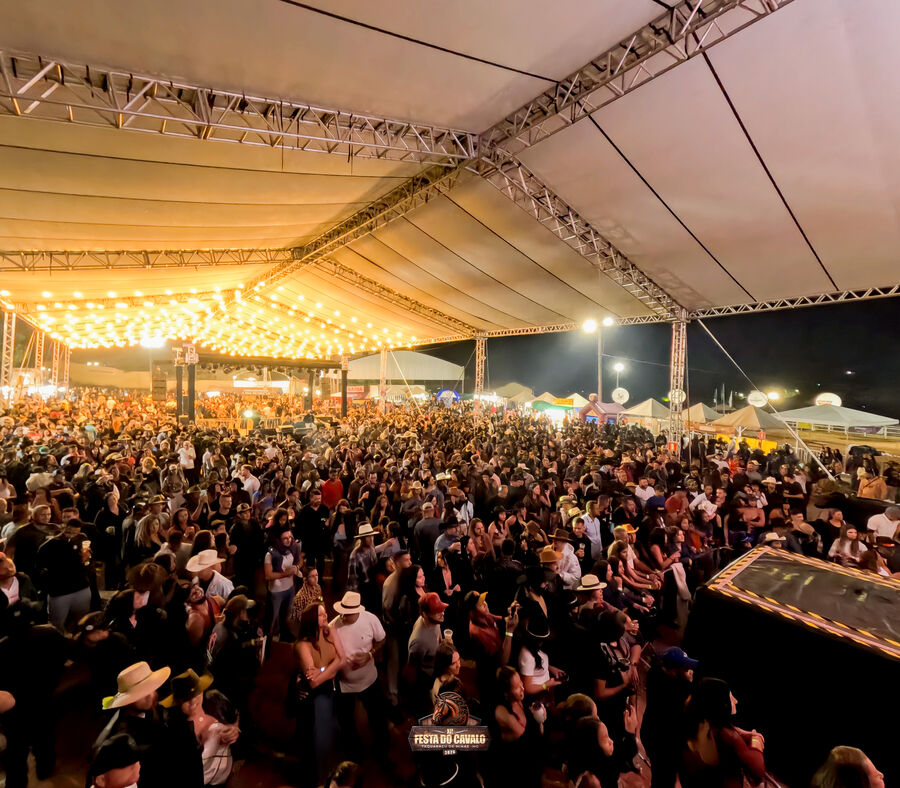 Tenda de grande porte com público durante evento noturno